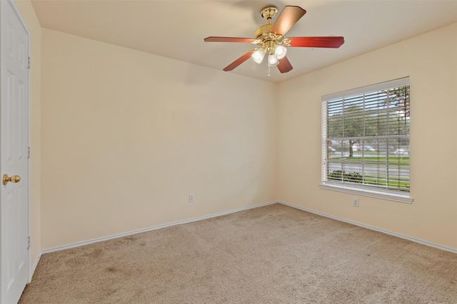 Secondary bedroom features carpet, ceiling fan, picture window and walk in closet. | Image 18