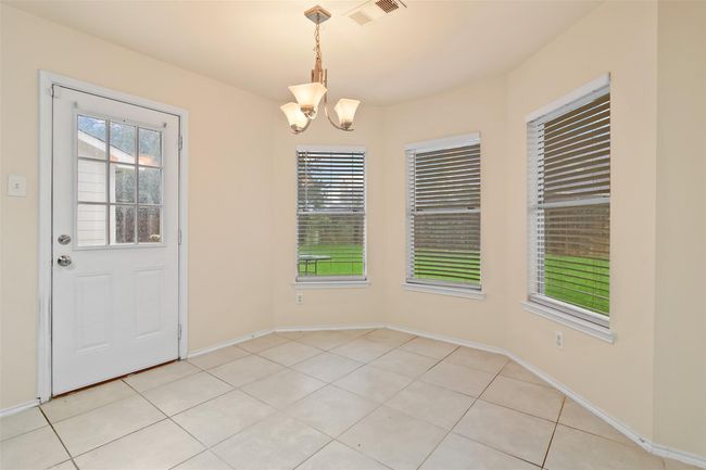 The breakfast room has tile floors and bay windows for more natural light. | Image 12