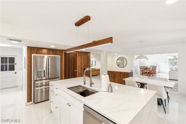 Kitchen with light stone counters, a sink, stainless steel appliances, recessed lighting, and modern cabinets | Image 6