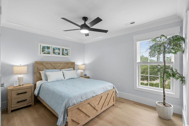 Bedroom featuring light wood-style floors, ceiling fan, and crown molding | Image 19