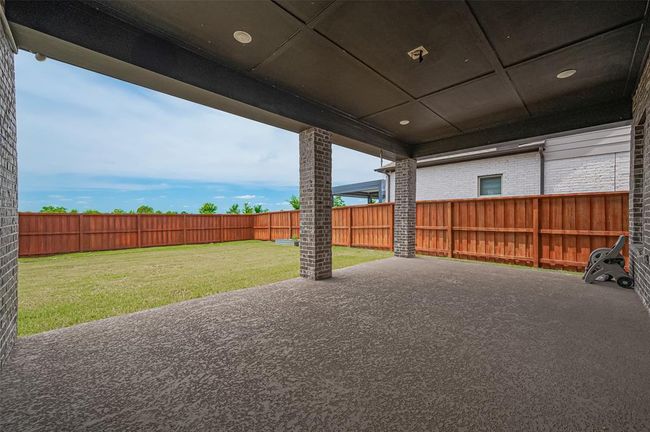 The covered patio is perfect for entertaining or relaxing year-round, while the lush green lawn provides ample space for kids, pets, or future landscaping projects | Image 34