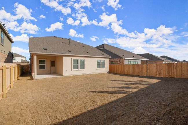 Rear view of house with roof with shingles, a fenced backyard, a patio, and stucco siding | Image 25