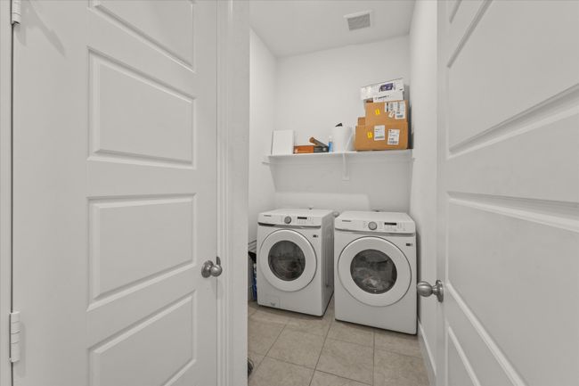 Washroom featuring washing machine and dryer and light tile patterned flooring | Image 10