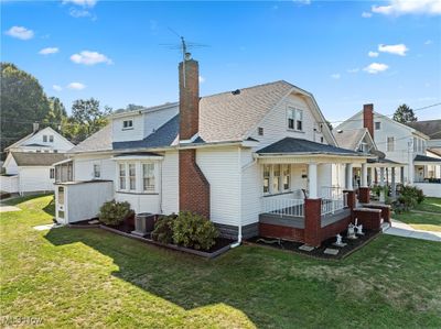 Back of property featuring a porch, a lawn, and cooling unit | Image 2