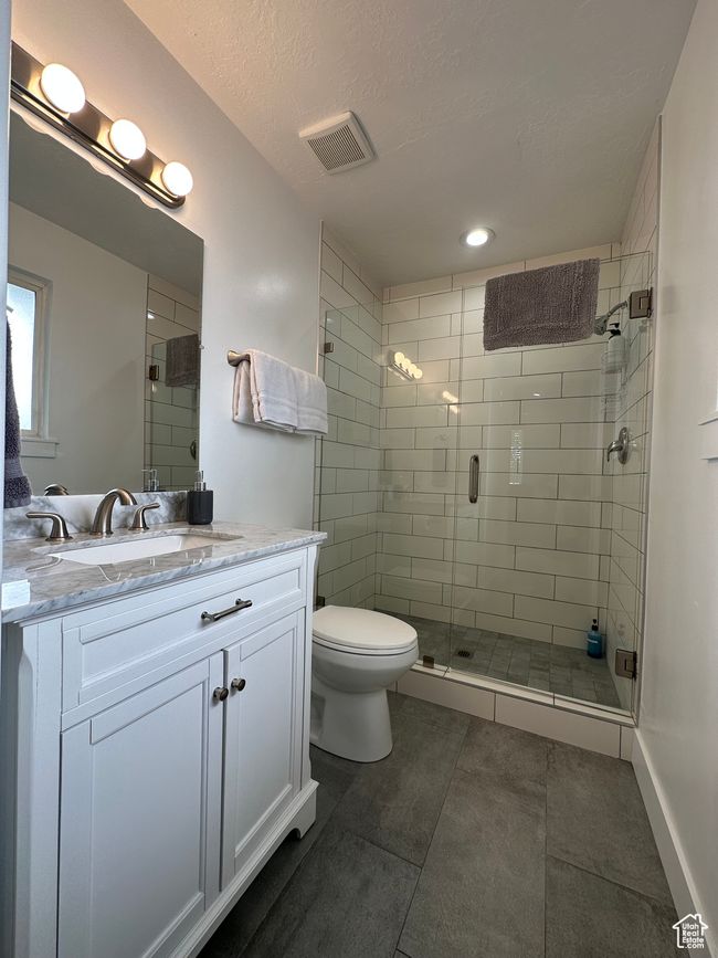 Full bath with tile patterned flooring, a stall shower, toilet, vanity, and a textured ceiling | Image 23