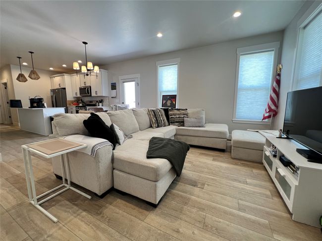 Living area featuring a chandelier, light wood-style flooring, and recessed lighting | Image 7