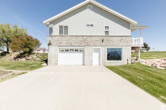 View of property exterior with an attached garage, a yard, and concrete driveway | Image 14