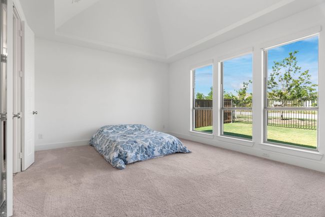 Bedroom featuring carpet flooring, vaulted ceiling, and baseboards | Image 31