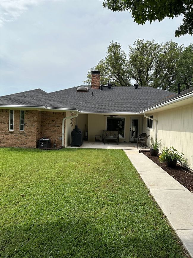 Rear view of property with a yard, a patio area, roof with shingles, and a chimney | Image 27