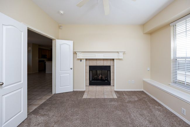 Unfurnished living room with a tile fireplace, carpet flooring, ceiling fan, and plenty of natural light | Image 7
