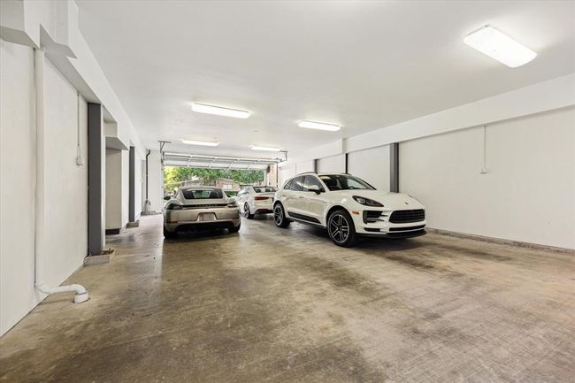 Another view of the expansive 43' x 25' x 9'.4" garage with high ceilings and clean, modern finishes. Easily accommodates 4–6 vehicles, including oversized models like a Ford F-450. Ideal for collectors, car enthusiasts, or those needing substantial storage or workshop space creates a functional, well-lit environment ready for customization or immediate use. A rare find in Oak Forest. | Image 38