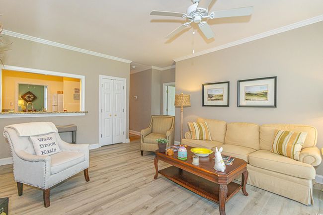 Living room with baseboards, ceiling fan, wood finished floors, and ornamental molding | Image 9