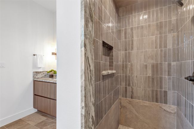 Bathroom featuring tiled shower and vanity | Image 17