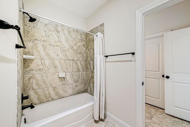 Bathroom with shower / tub combo and baseboards | Image 24