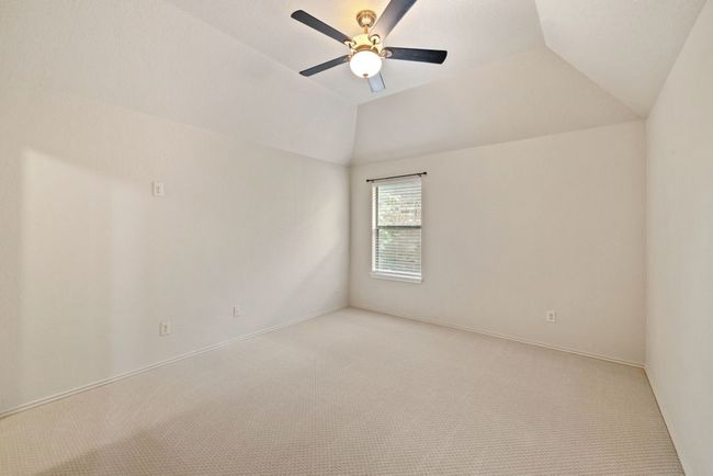 Unfurnished room with ceiling fan, light colored carpet, and lofted ceiling | Image 24