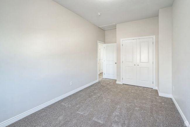 Unfurnished bedroom with carpet, a closet, and attic access | Image 36