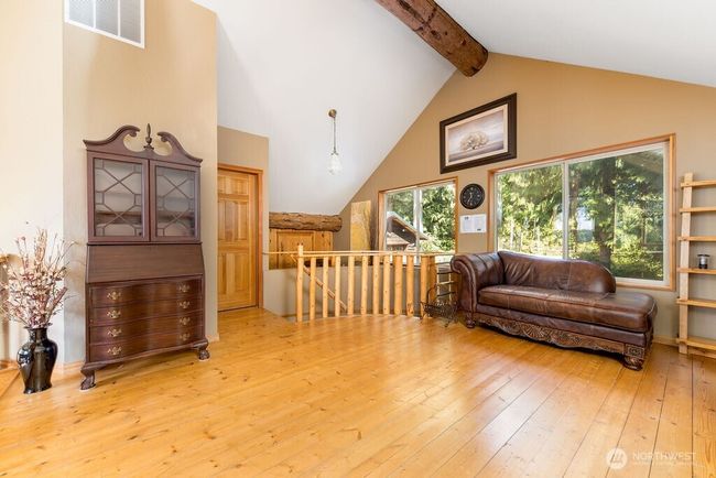Eagle's view loft with natural light, vaulted ceiling overlooking home entrance. | Image 15
