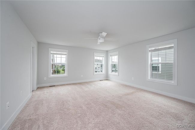 Carpeted empty room with ceiling fan and baseboards | Image 13