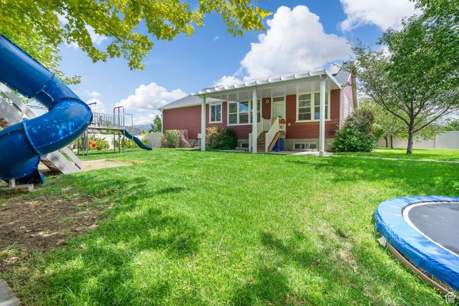 View of yard featuring a playground and a trampoline | Image 37