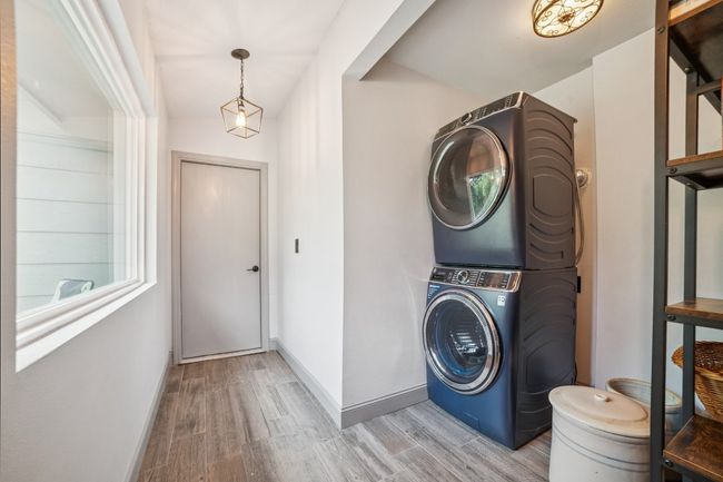 Laundry room with stacked washer and dryer and door to garage | Image 27