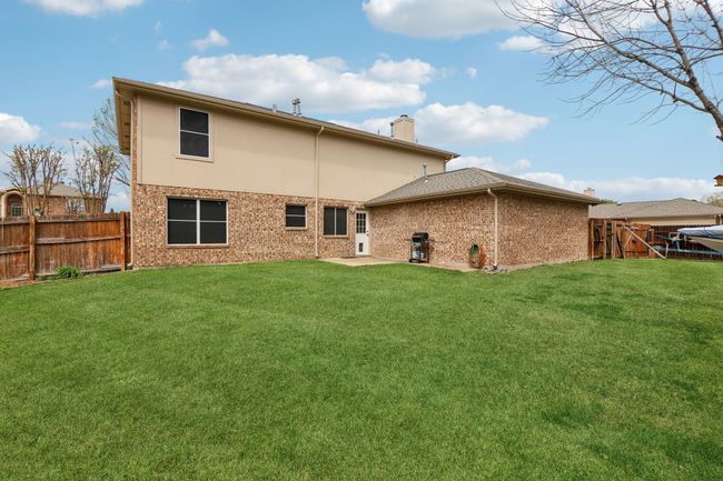 Back of property with a fenced backyard, brick siding, a yard, and a chimney | Image 31