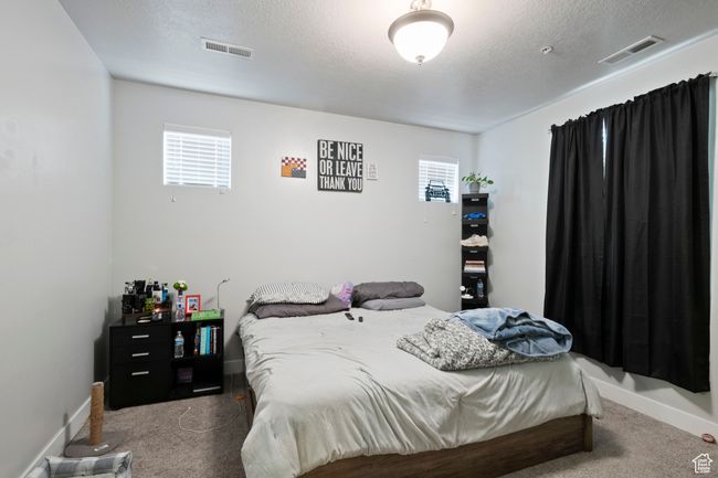 Bedroom with carpet, a textured ceiling, and baseboards | Image 8