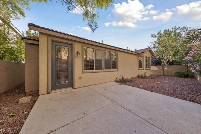 Back of property featuring stucco siding, a tile roof, a fenced backyard, and a patio area | Image 10