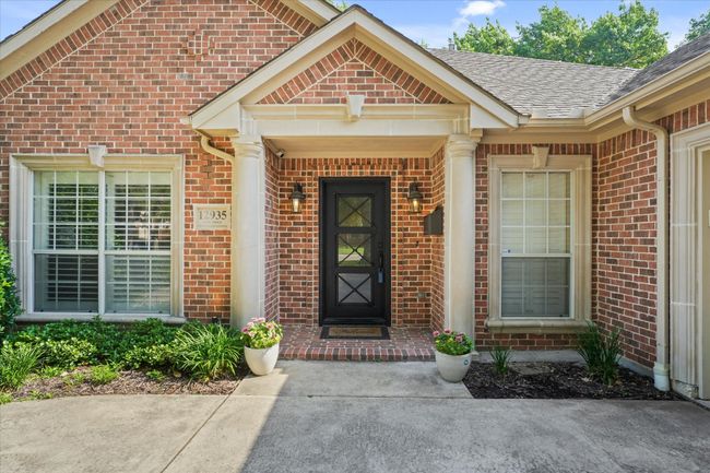 Doorway to property featuring brick siding and a shingled roof | Image 5