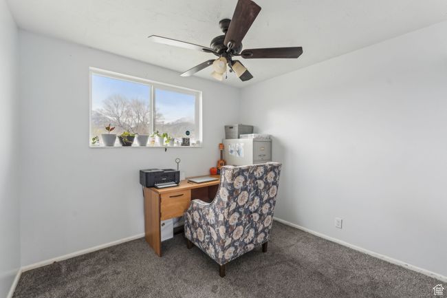 Carpeted home office featuring a ceiling fan and baseboards | Image 14