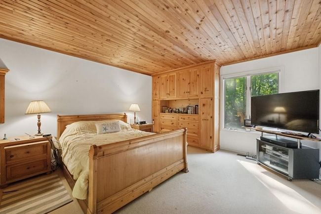 Bedroom featuring wooden ceiling and light carpet | Image 8