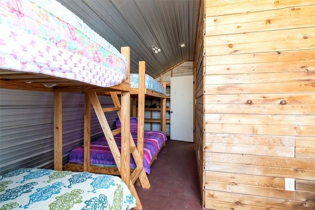 Bunkhouse dedroom with lofted ceiling, and wooden walls | Image 28
