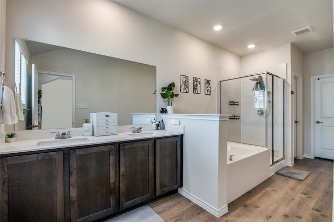 Bathroom with wood finished floors, a shower stall, double vanity, and recessed lighting | Image 20