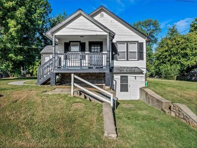 Bungalow-style house featuring a porch and a front yard | Image 1