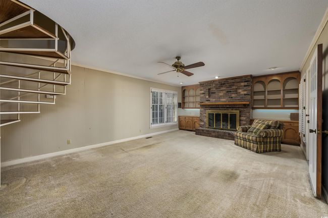 Unfurnished living room featuring a fireplace, ceiling fan, carpet, and ornamental molding | Image 19