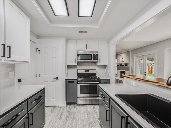 Kitchen featuring visible vents, a sink, a raised ceiling, light countertops, and appliances with stainless steel​​‌​​​​‌​​‌‌​‌‌​​​‌‌​​‌‌​‌​​​​​‌ finishes | Image 8