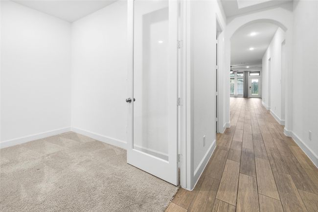 Bright hallway with tile flooring leading to a spacious living area. | Image 4