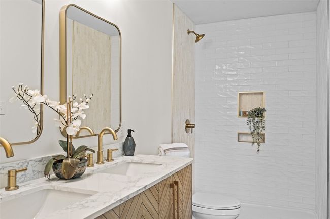 Bathroom featuring toilet, double vanity, and a shower | Image 25