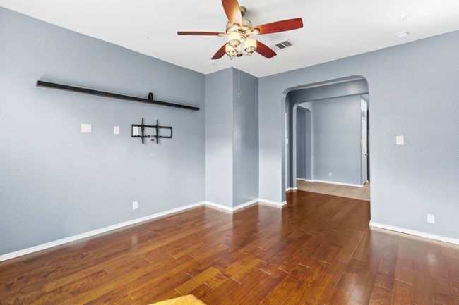 Empty room with arched walkways, wood finished floors, and ceiling fan | Image 22