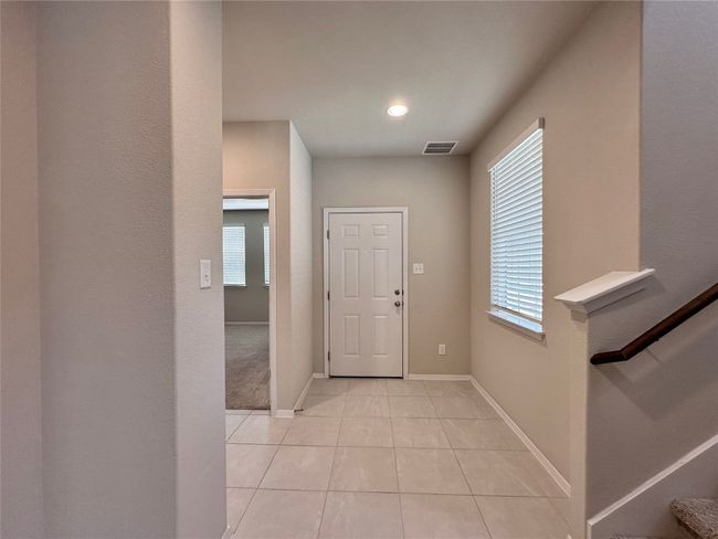 Entryway with healthy amount of natural light, light tile patterned floors, and stairway | Image 10
