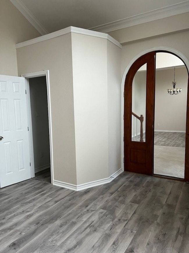 Foyer with ornamental molding, wood finished floors, arched walkways, and baseboards | Image 4