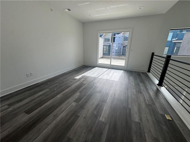 Unfurnished room featuring dark wood-style floors, baseboards, and visible vents | Image 23