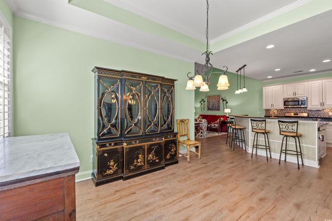 Dining area with a chandelier, crown molding, light wood finished floors, and recessed lighting | Image 16