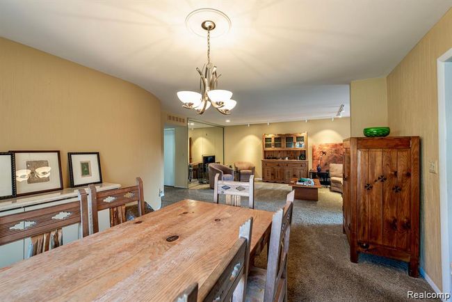 Dining area with dark colored carpet and a chandelier | Image 16