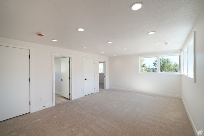 Unfurnished bedroom featuring light carpet, recessed lighting, baseboards, and a textured ceiling | Image 27