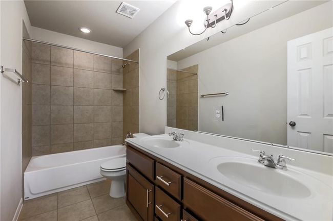 Full bath with tile patterned floors, double vanity, and tub / shower combination | Image 24