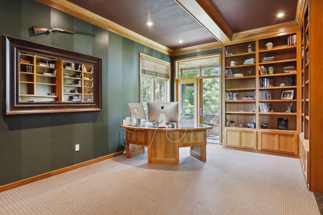 What a perfect setup to work or run your business from home! Take a break from the hustle and soak up your surroundings right from your private office space Main floor office with easy access to the screen porch offering serene lake / treed views. | Image 18