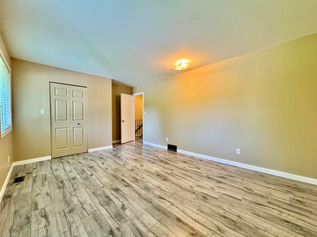 Unfurnished bedroom featuring wood finished floors, a textured ceiling, and a closet | Image 11