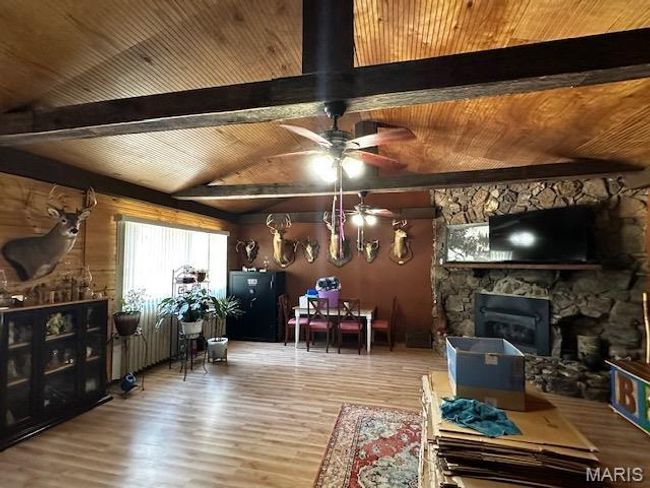Living room with lofted ceiling with beams, a fireplace, hardwood / wood-style floors, and wooden ceiling | Image 14