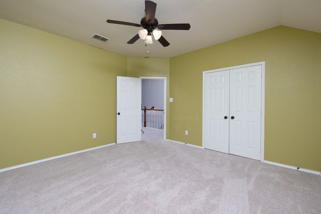 Unfurnished bedroom with carpet floors, a closet, a ceiling fan, and lofted ceiling | Image 26