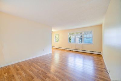 Unfurnished room with light hardwood / wood-style floors and a baseboard heating unit | Image 2